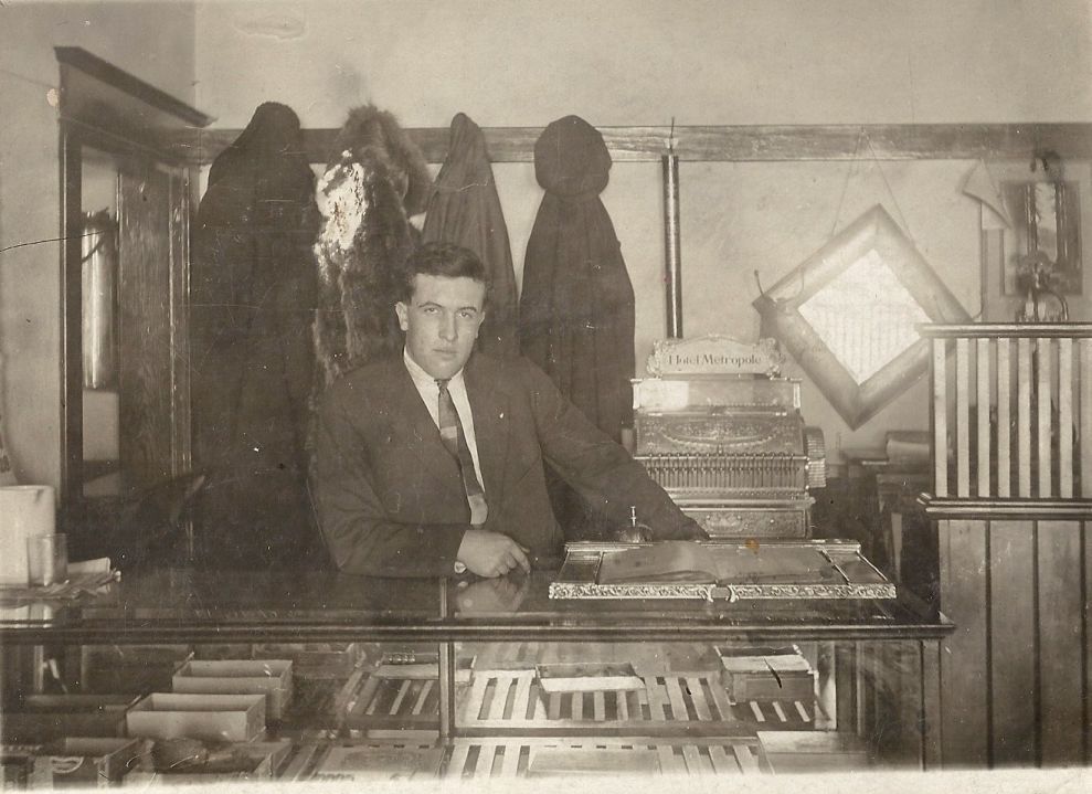 Aimé Hubert Brooks sitting at the front desk of the Metropole Hotel Lafleche Saskatchewan